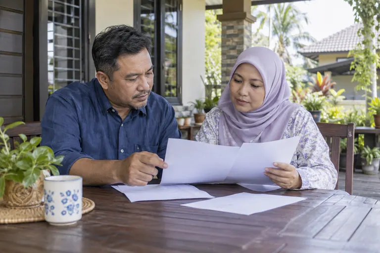 Dua pelanggan membaca kertas kosong di meja beranda